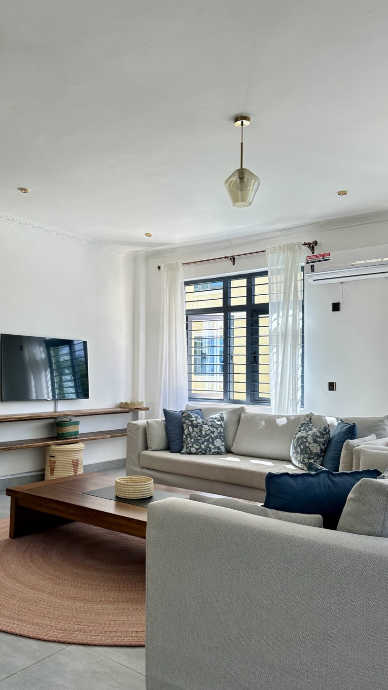 The living room's TV wall and floating shelves